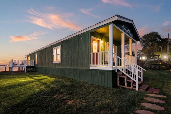A wooden building with a porch and a staircase, labeled 'Sunset Cove.'