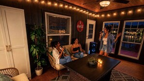 A cozy indoor space with a dining table, chairs, a potted plant, and a view of a body of water. - Lake Front Lake House Paradise! (Pittsburg)