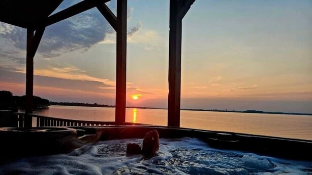 A hot tub with a sunset view. - Lake Front Lake House Paradise! (Pittsburg)