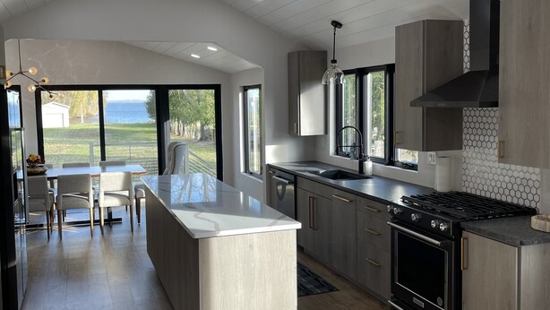 Una cocina moderna con una isla central, ventanas amplias y vistas al exterior.