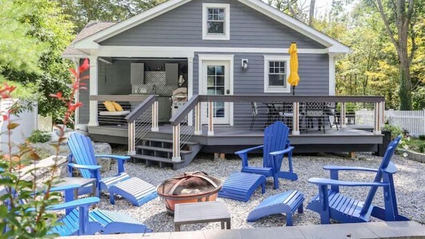 A two-story house with a covered porch, outdoor seating area, and a fire pit. - Updated cottage "Beriozka" on Cedar Lake (Chester)