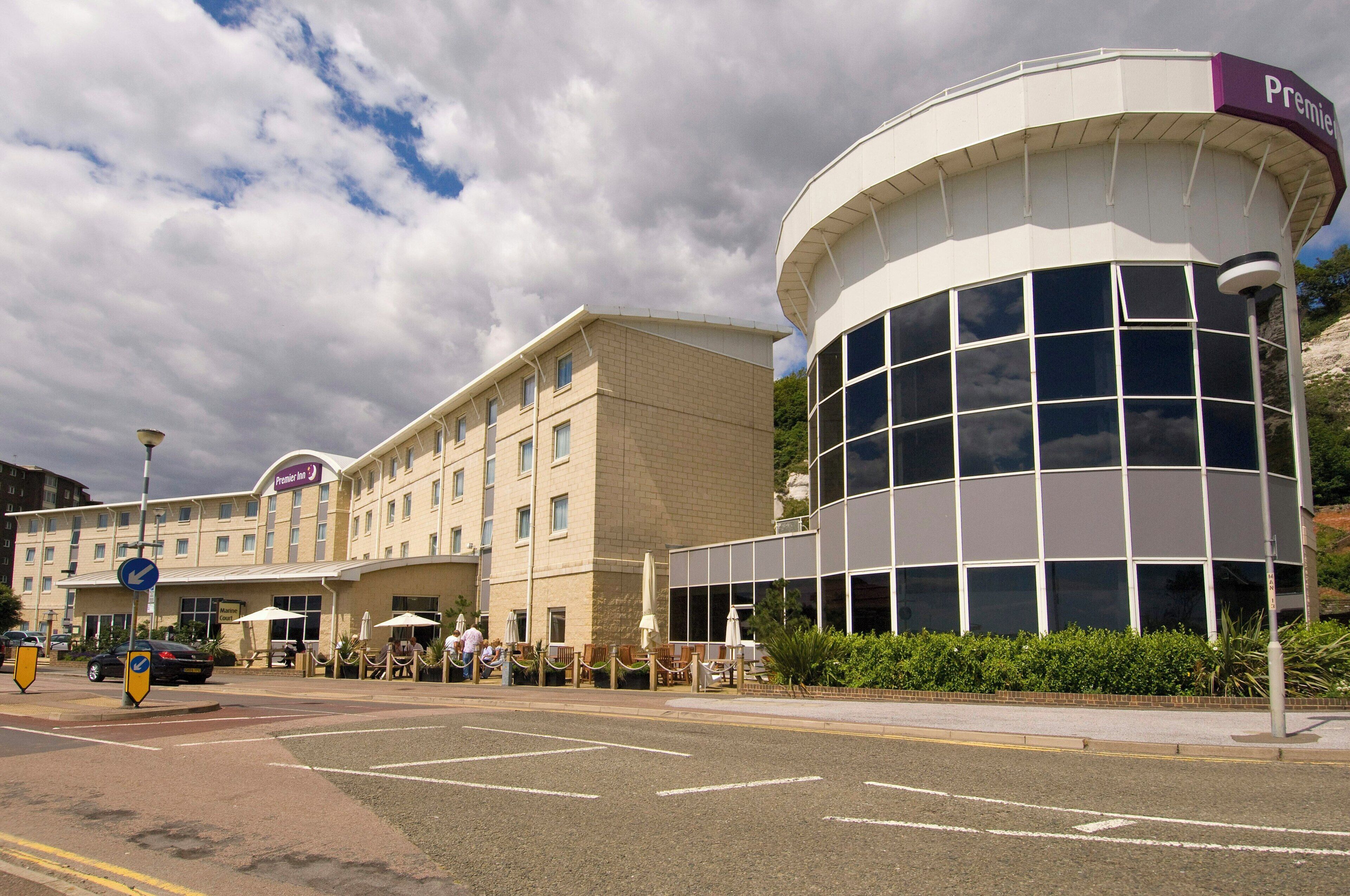 A hotel with a prominent curved glass building and a flat-roofed structure.