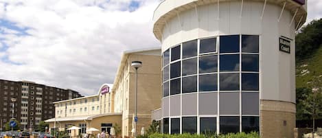 A hotel with a prominent curved corner, a sign for the Premier Inn, and a Marine Court sign.
