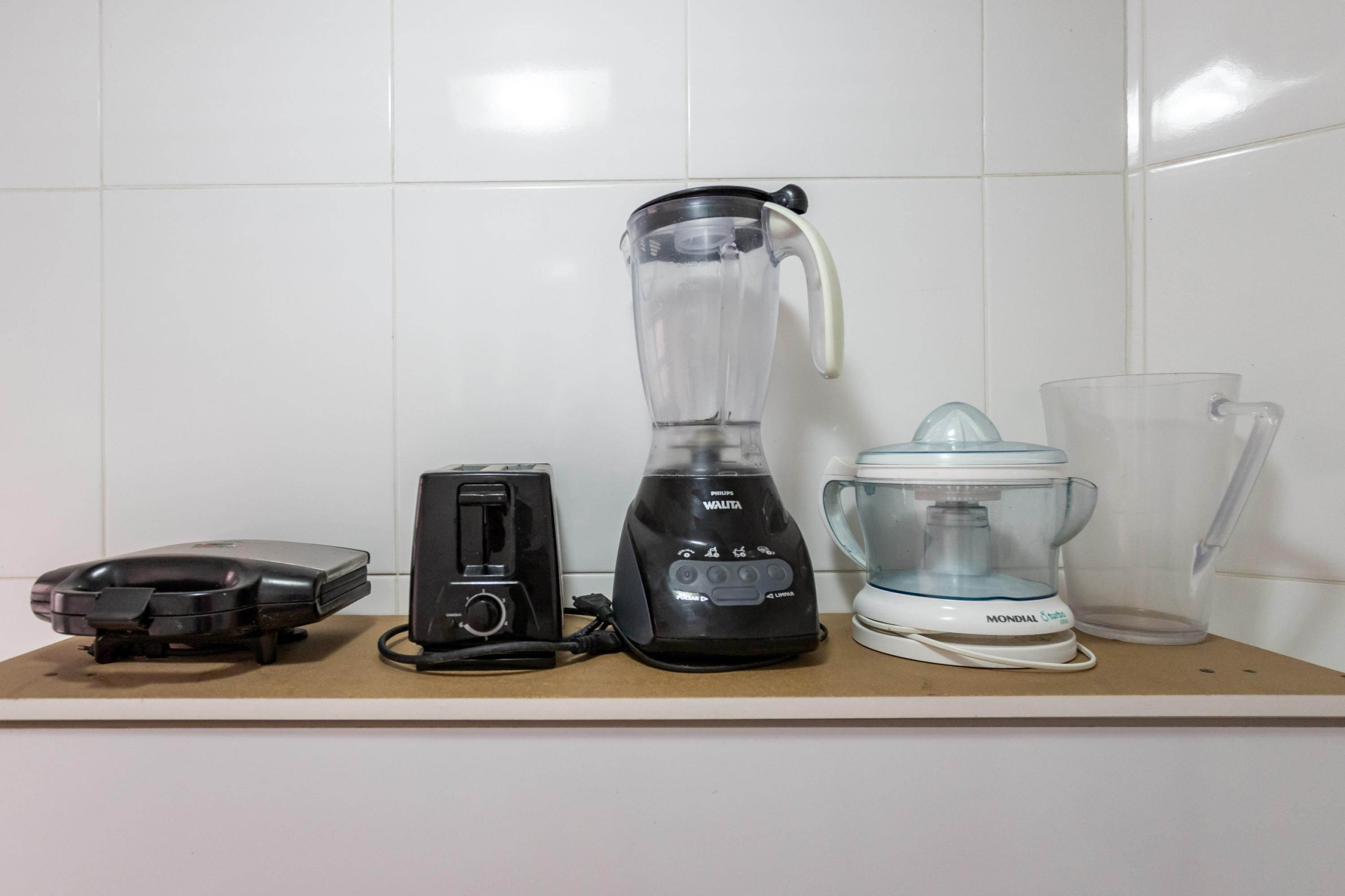 Eine Küchenarbeitsplatte mit Toaster, Mixer, Kaffeemaschine und einem Glasbehälter.