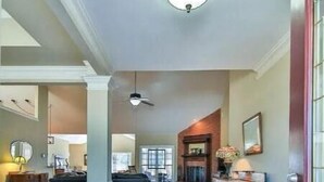 A spacious hallway with a wooden floor, a round rug, and a fireplace. - PGA WEST CONDO with view of the mountains! Located in Palmer Private on hole#4 (La Quinta)