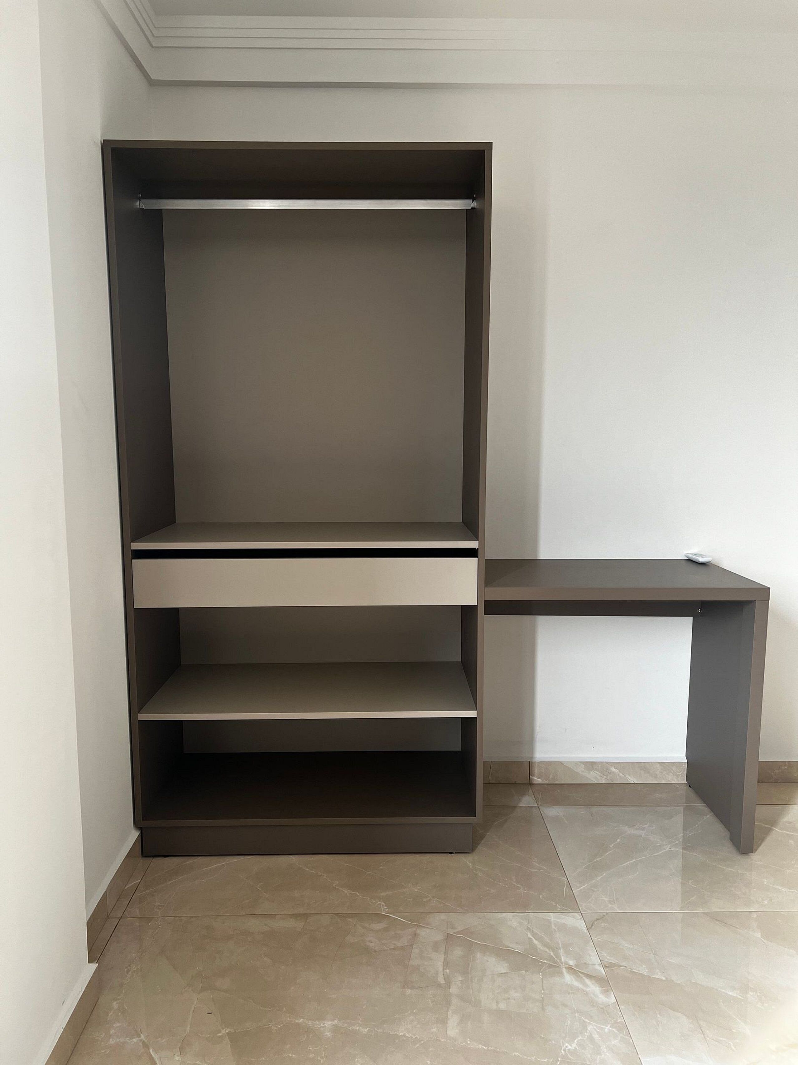 A corner room with a built-in shelving unit and a desk.