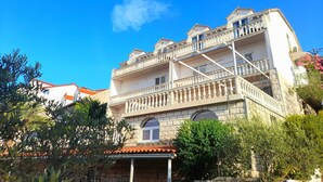 A multi-story building with balconies and a stone facade.