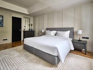A modern bedroom with a large bed, bedside tables, and a decorative mirror. - Floral Court Hotel and Residence (Bangkok)