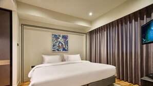 A hotel room with a large bed, a flat-screen TV, and a painting on the wall. - Floral Court Hotel and Residence (Bangkok)