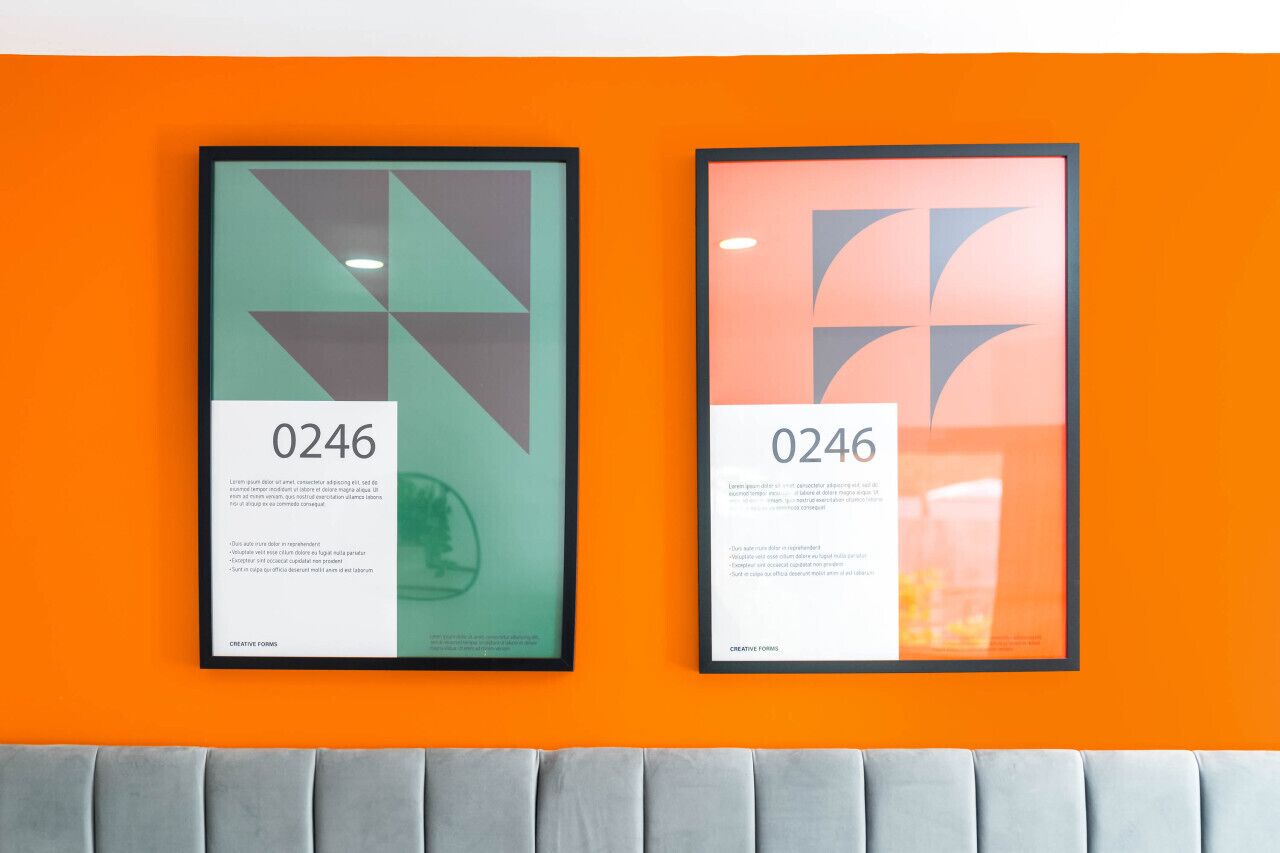 Two framed artworks with the number 0246 on a bright orange wall.
