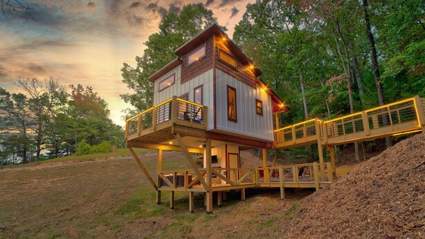 A wooden cabin with a balcony and a deck, surrounded by trees. - Cozy Couples Treehouse w Hot Tub, Fire Pit, Pet Friendly, Lake Access (Morganton)