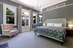 A bedroom with a large bed, a chair, a chandelier, and a view of the outdoors. - Coryong - A grand residence, 500m from Leura mall (Leura)