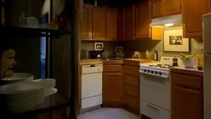 Une cuisine avec des meubles de rangement en bois, une cuisinière, un lave-vaisselle et un réfrigérateur.