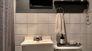 Une salle de bain avec des toilettes, un lavabo et une serviette accrochée au mur.