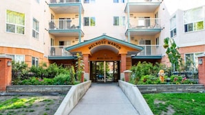 Un immeuble à plusieurs étages avec une entrée principale portant l’inscription « MELROSE MANOR ».