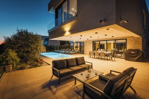 Eine moderne Außenpatio mit Pool, Sitzbereich und Essbereich.