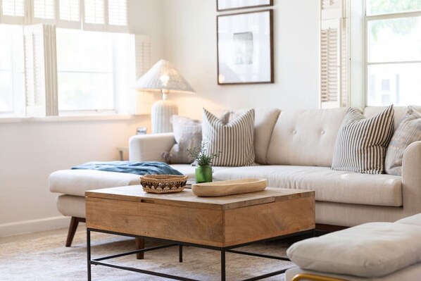 A living room with a sofa, a coffee table, and a lamp. - House of Rio, Seaside Getaway (Jensen Beach)