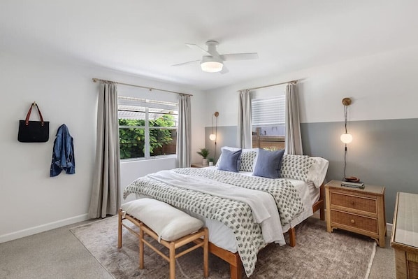 A bedroom with a bed, bedside table, and a window with curtains. - House of Rio, Seaside Getaway (Jensen Beach)
