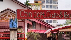 A restaurant named "Concept Cafe & Bar" with outdoor seating and a red awning.