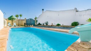 A swimming pool with clear blue water, surrounded by a white wall and a stone border. - Nice home in Casariche (Casariche)