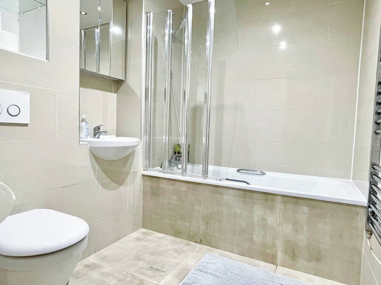 A bathroom with a toilet, sink, and shower area.