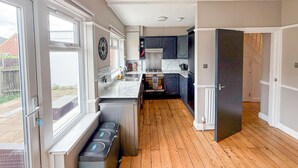 A modern kitchen with a central island, built-in appliances, and large windows.