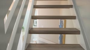 A modern staircase with wooden steps and white railings. - Moguls | Lofted Ski in Ski Out w/ Hot Tub Access (Panorama)
