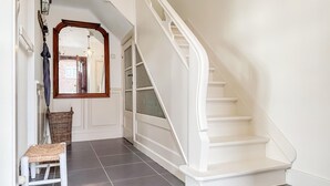A staircase with white railings and a handrail, leading to a door with frosted glass panels.