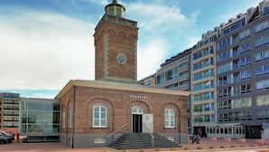 A building with a prominent brick tower and a modern glass facade.