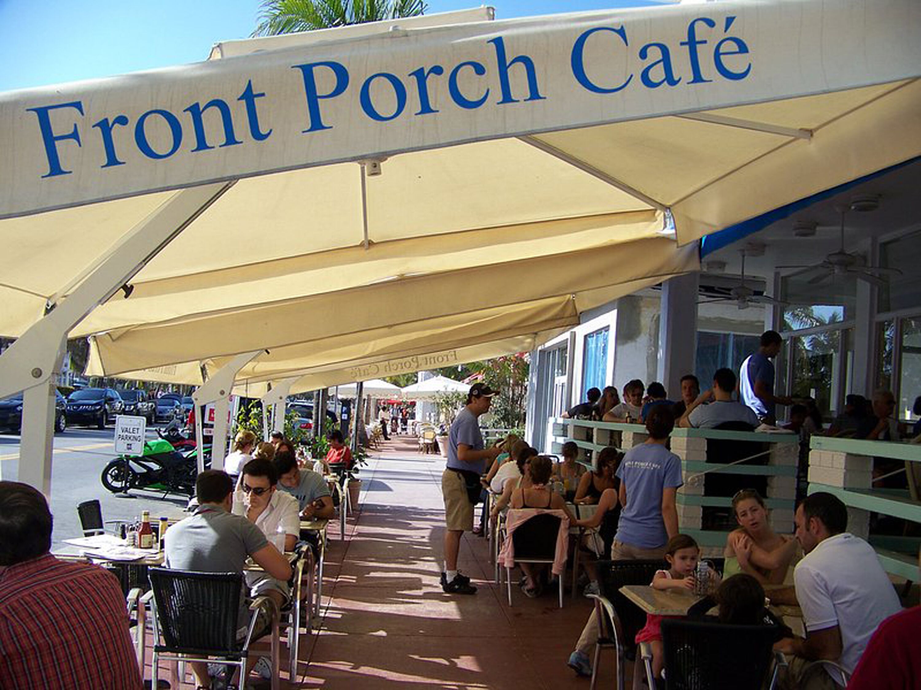 A Front Porch Café with outdoor seating under a canopy, tables, and chairs arranged for guests.