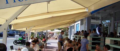 A Front Porch Café with outdoor seating under a canopy, tables, and chairs arranged for guests.