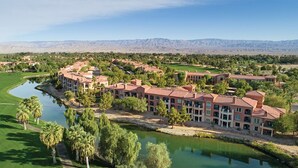 A resort with multiple buildings, a central courtyard, and a body of water.