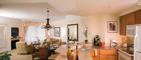 A modern kitchen with granite countertops, a central island, and wooden cabinets.
