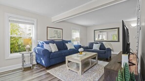 A living room with two sofas, a coffee table, and a TV.
