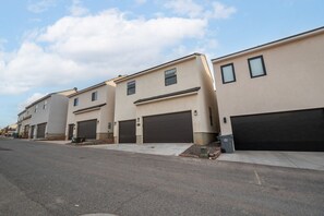 A row of modern, single-story buildings with large garage doors, likely residential units.