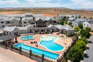 A residential area with multiple houses, a swimming pool, and a fenced patio area. - Large 5 bedroom with double bunkroom and pool (Hurricane)