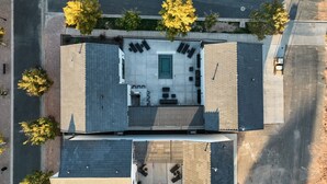 Ilmakuva modernista rakennuksesta, jossa on kattoterassi, uima-allas ja katettu ulkoalue oleskelua varten.