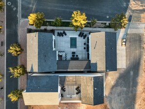 An aerial view of a building with a rooftop terrace, a swimming pool, and a covered outdoor seating area.
