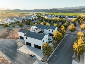 Un quartier résidentiel avec des maisons modernes, une route dégagée et une vue sur les montagnes lointaines.