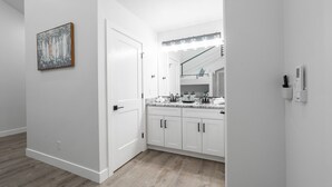 Une salle de bain moderne avec un meuble-lavabo, un miroir et des luminaires.