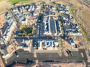 Ett flygbildsbild av ett bostadsområde med flera byggnader, vägar och en parkeringsplats.
