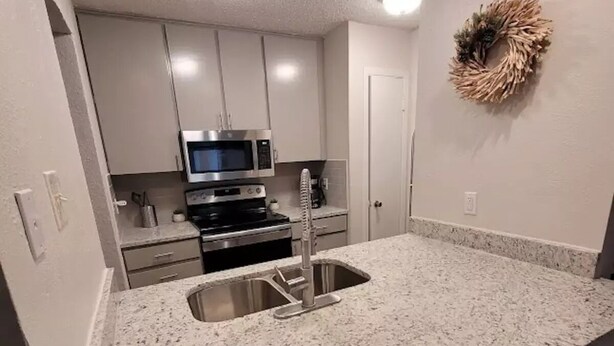 A modern kitchen with granite countertops, stainless steel appliances, and a built-in sink.