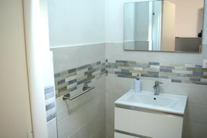 Een douche, een haardroger, een bidet, handdoeken