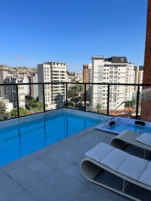 A rooftop pool area with a view of surrounding buildings.