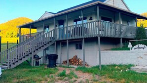 A two-story building with a balcony, a staircase, and a 'welcome' sign. - Charming farmhouse property on 20 acres of land, comfortably sleeps 13   (Lava Hot Springs)