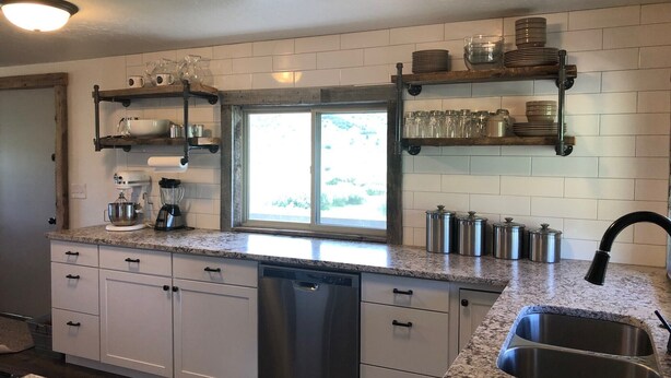 A kitchen with white cabinets, granite countertops, a dishwasher, and stainless steel appliances. - Charming farmhouse property on 20 acres of land, comfortably sleeps 13   (Lava Hot Springs)
