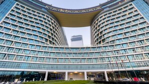 A modern hotel with a curved facade, large glass windows, and a central atrium. - Modern studio on Palm Jumeirah (Dubai)