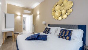 Et hotelværelse med en stor seng, et skrivebord og en dekorativ genstand på væggen.