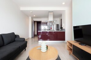 A modern living room with a black sofa, a wooden coffee table, and a flat-screen TV. - Beautiful design in Polanco, 2 rooms (Ciudad de México)