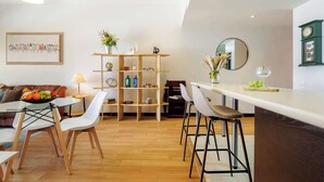 Une cuisine moderne avec un coin bar, un plancher en bois et un ensemble de salle à manger.